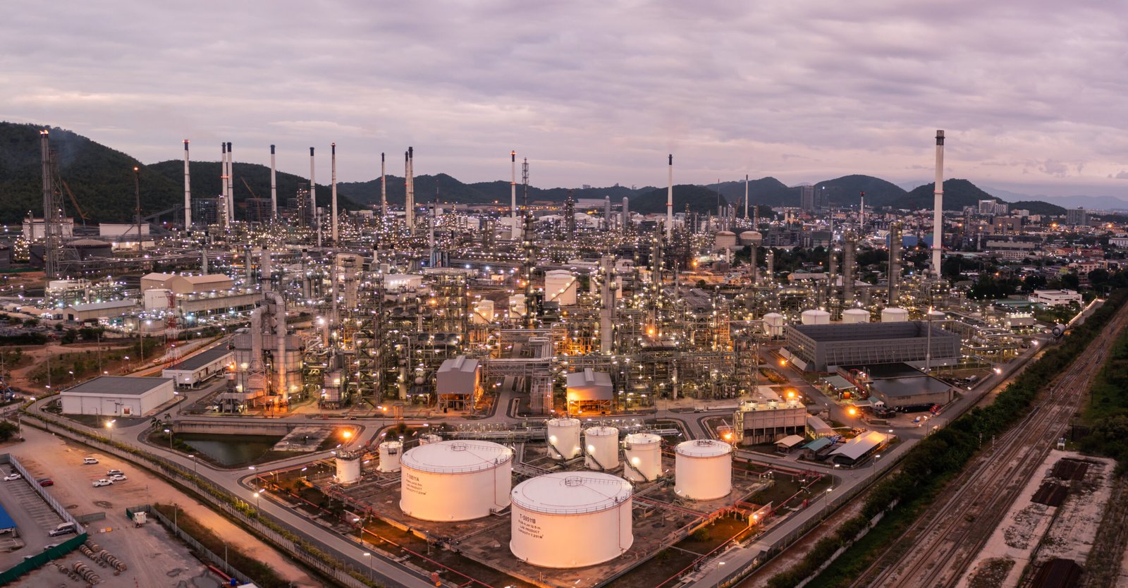 Aerial view drone of oil storage tank with oil refinery factory industrial. Oil refinery plant at beautiful sky sunset and twilight. industry factory concept and transportation.